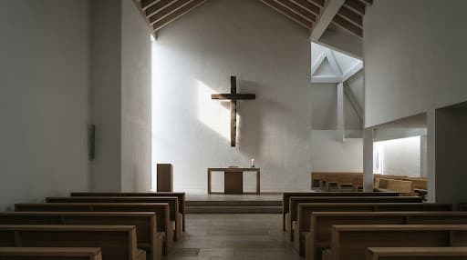 Intérieur d'église moderne et minimaliste, croix en bois illuminée par un rayon de lumière naturelle